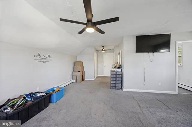an empty room with windows and ceiling fan