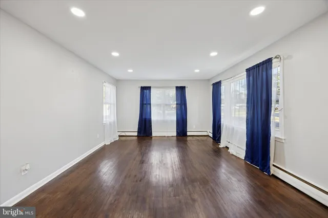 an empty room with wooden floor and window