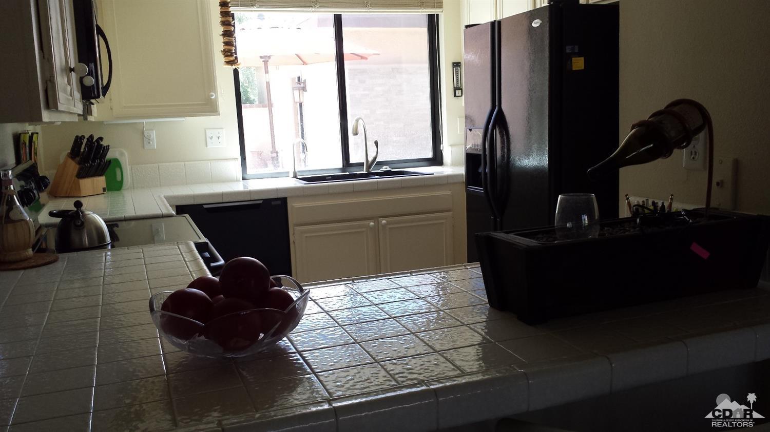 19 La Ronda Drive Rancho Mirage, CA 92270 - Photo 3 of 11 a kitchen with a sink and a refrigerator