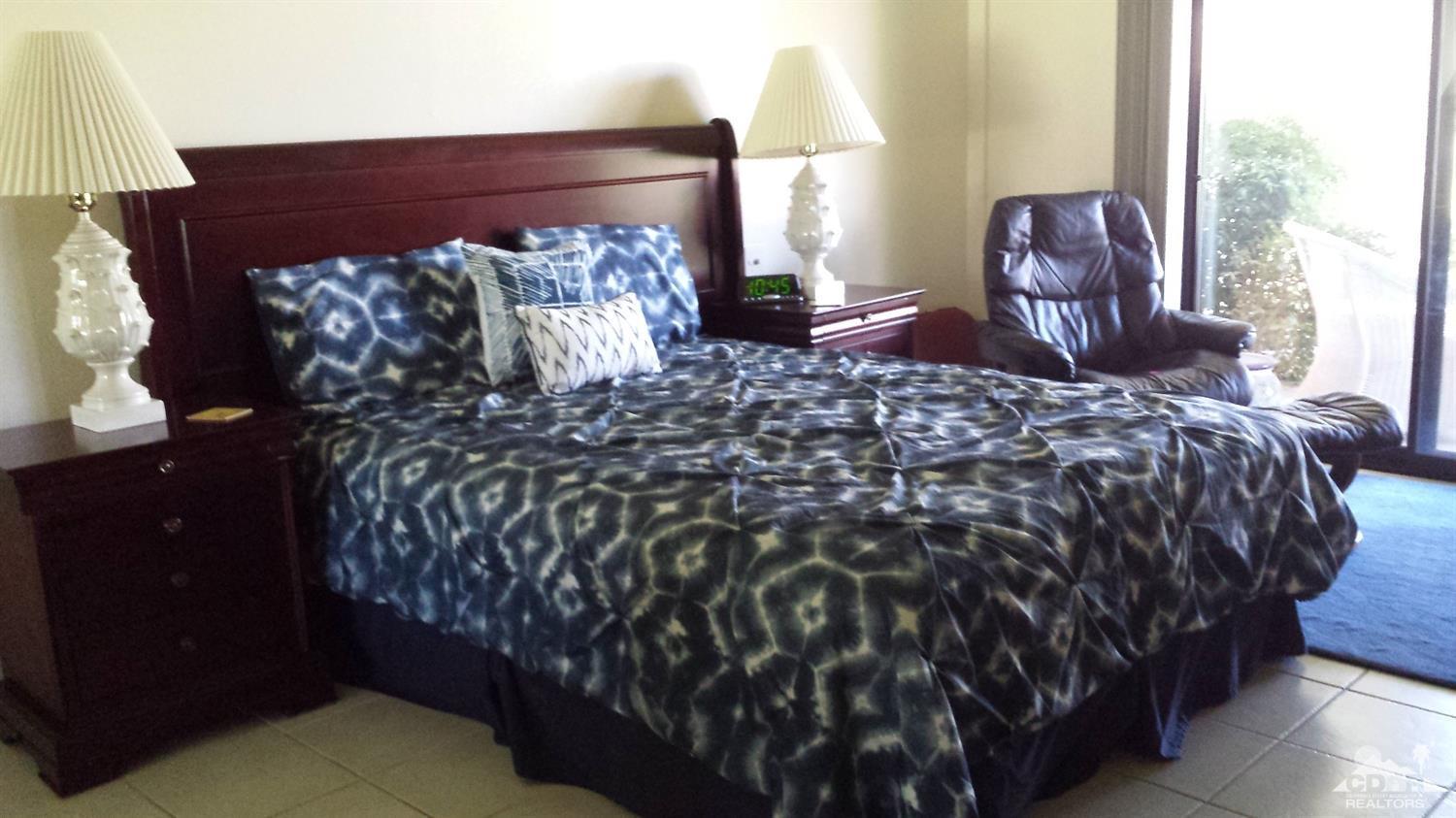 19 La Ronda Drive Rancho Mirage, CA 92270 - Photo 6 of 11 a bed sitting in a bedroom next to a lamp