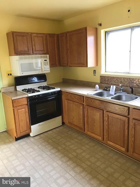 1419 Hallwood Road Baltimore, MD 21228 - Photo 4 of 14 a kitchen with a stove sink and cabinets
