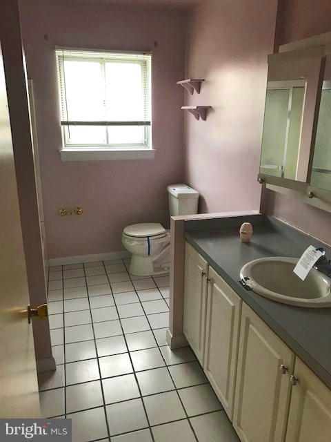 1419 Hallwood Road Baltimore, MD 21228 - Photo 5 of 14 a bathroom with a sink a toilet and a mirror