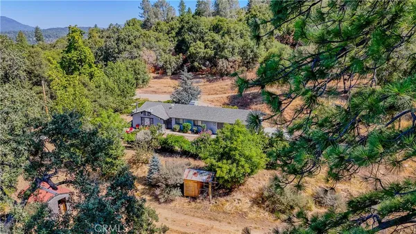 an aerial view of a house with yard and outdoor seating