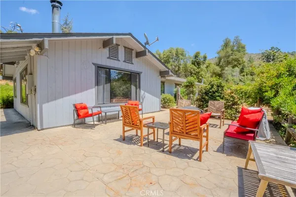 a view of a chairs and table in the back yard of the house