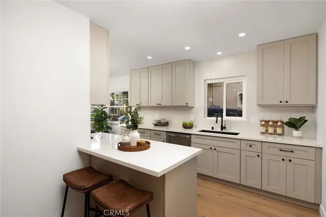 a kitchen with a sink cabinets and wooden floor