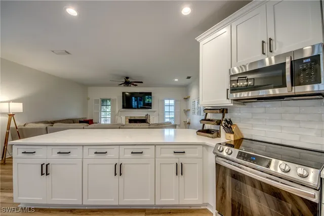 a kitchen with granite countertop a sink a stove and cabinets
