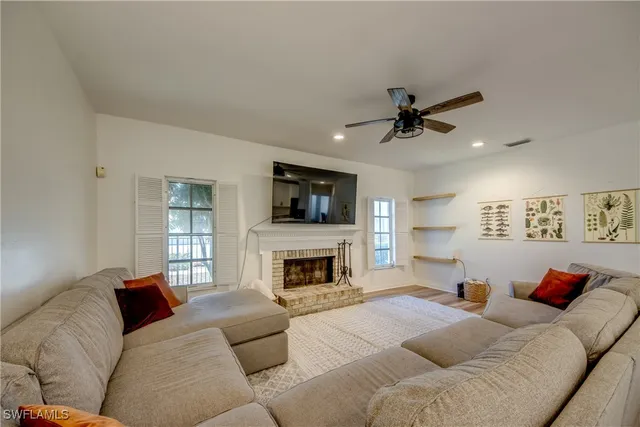 a living room with furniture a fireplace and a flat screen tv