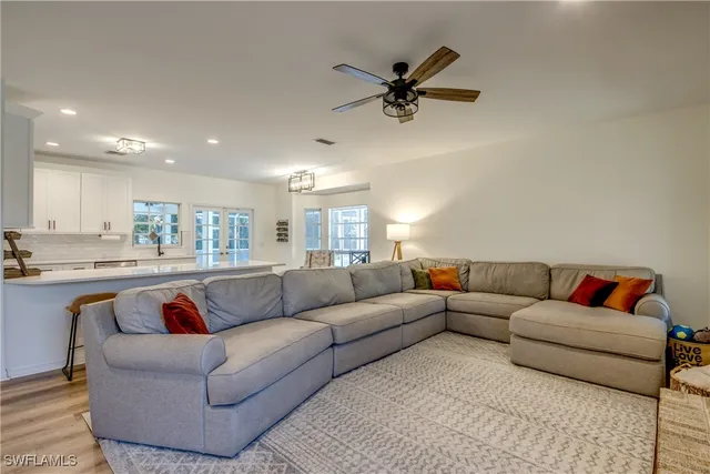 a living room with furniture and a view of kitchen