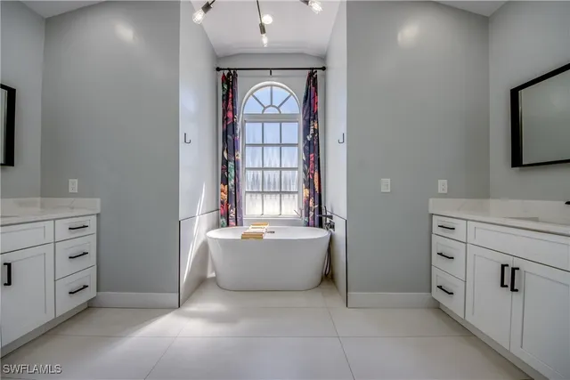 a bathroom with a bathtub sink and mirror