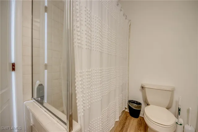 a white toilet sitting next to a shower
