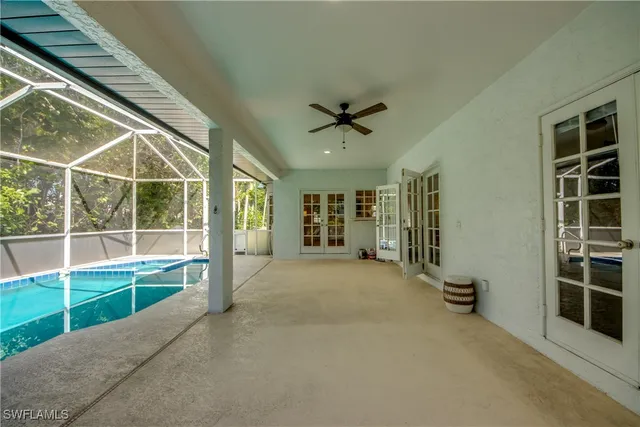 a view of an empty room with a window and a kitchen