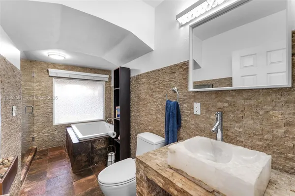 a bathroom with a sink a toilet and mirror