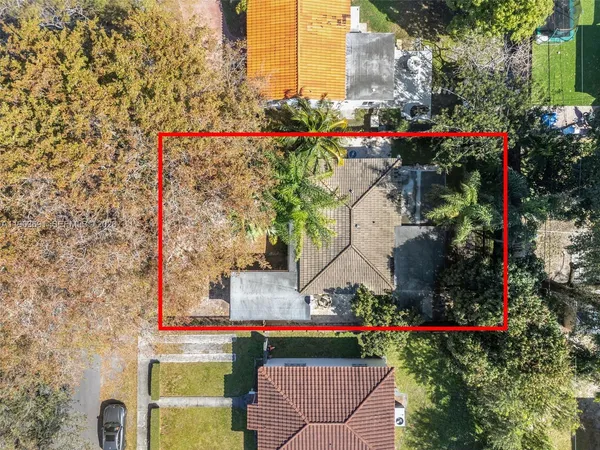 an aerial view of residential houses with outdoor space and trees