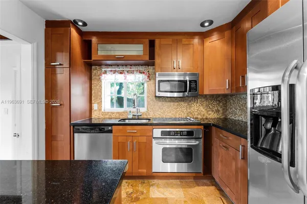 a kitchen with stainless steel appliances granite countertop a stove a sink and a refrigerator