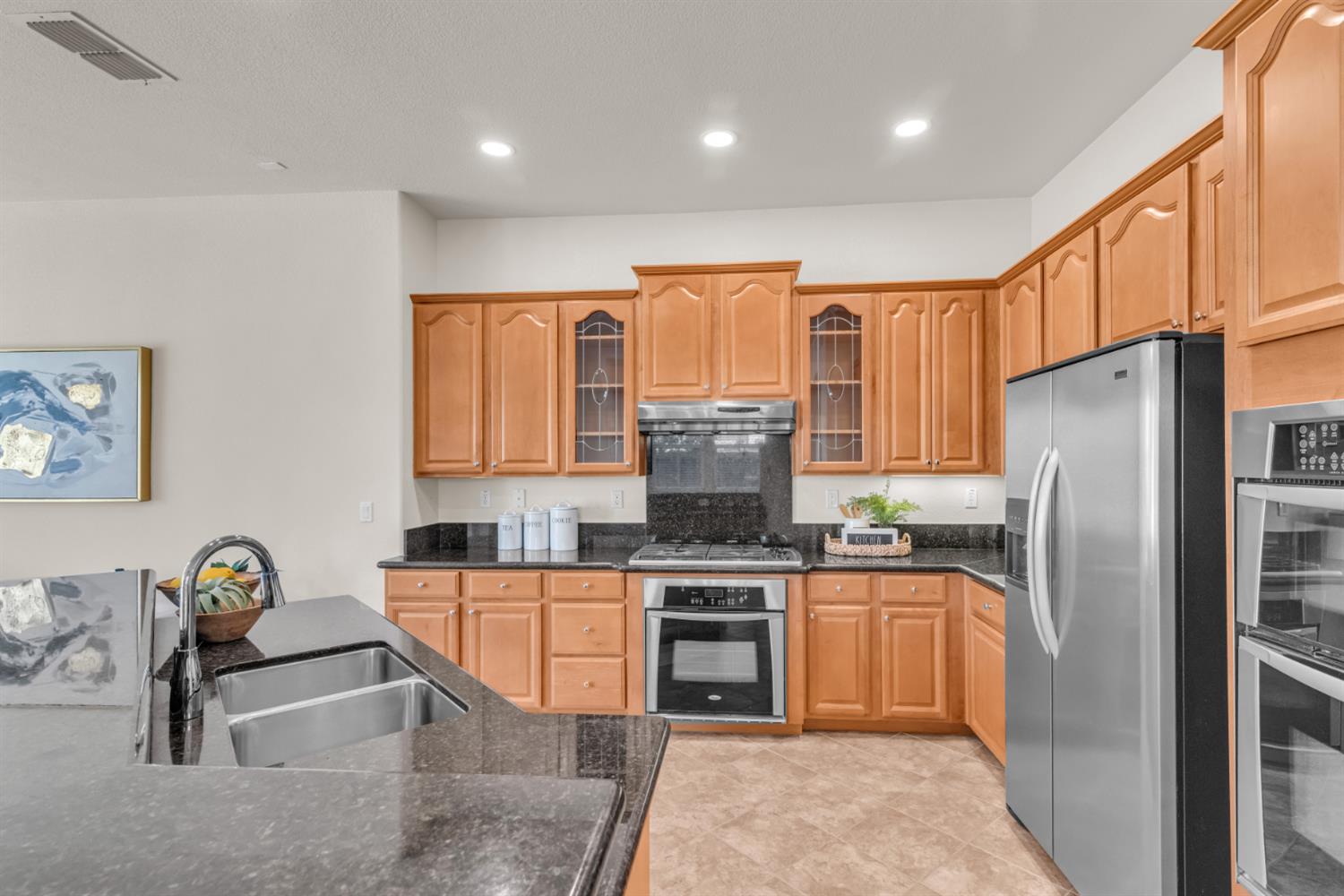 2152 Ritchie Street Folsom, CA 95630 - Photo 16 of 47 Kitchen featuring wood-finish cabinetry, dark stone countertops, and stainless steel appliances