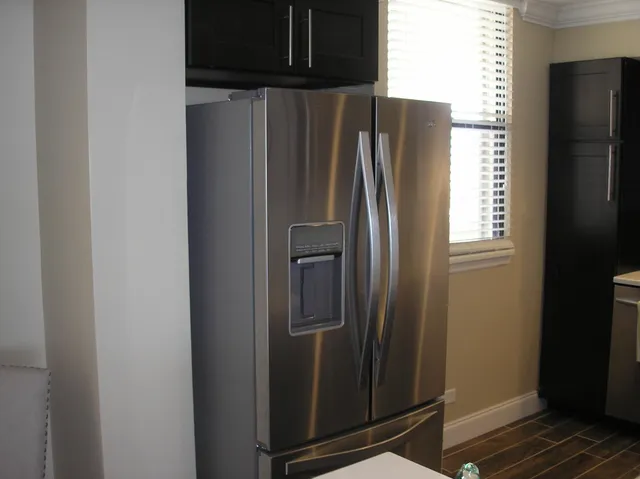 a metallic refrigerator freezer sitting inside of a kitchen