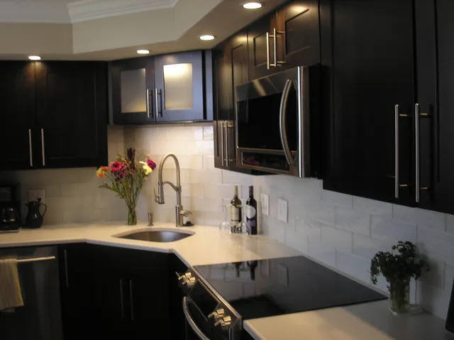 a kitchen with stainless steel appliances a sink dishwasher a refrigerator and cabinets with wooden floor