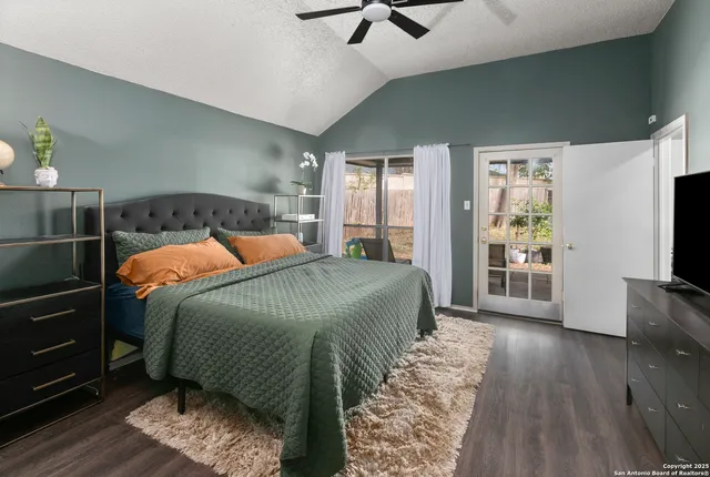 a bedroom with a bed and a flat tv screen on dresser