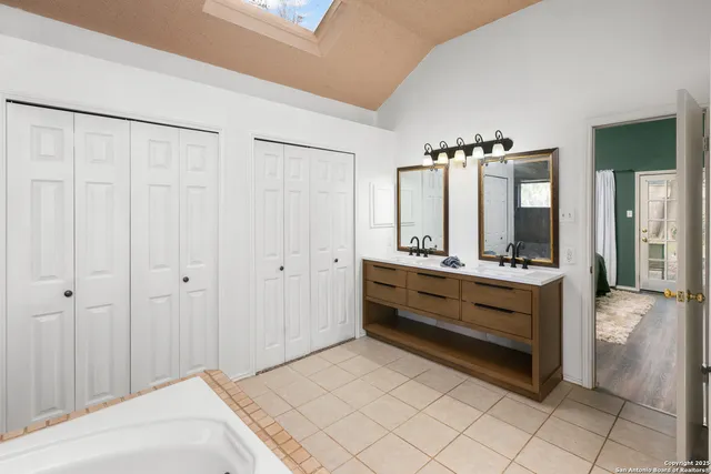a bathroom with a double vanity sink and mirror