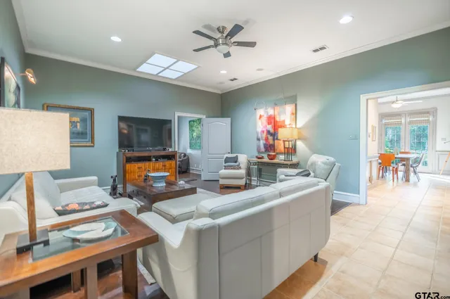 a living room with furniture a chandelier and a flat screen tv