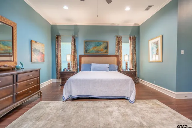 a bedroom with a bed and dresser with mirror