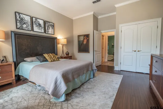 a bedroom with a large bed and a chandelier