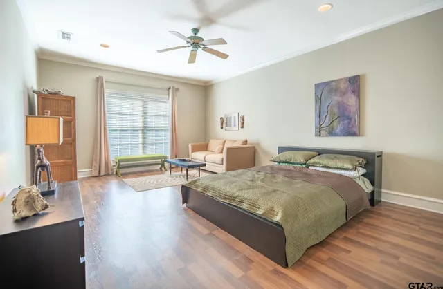 a spacious bedroom with a large bed and a chandelier