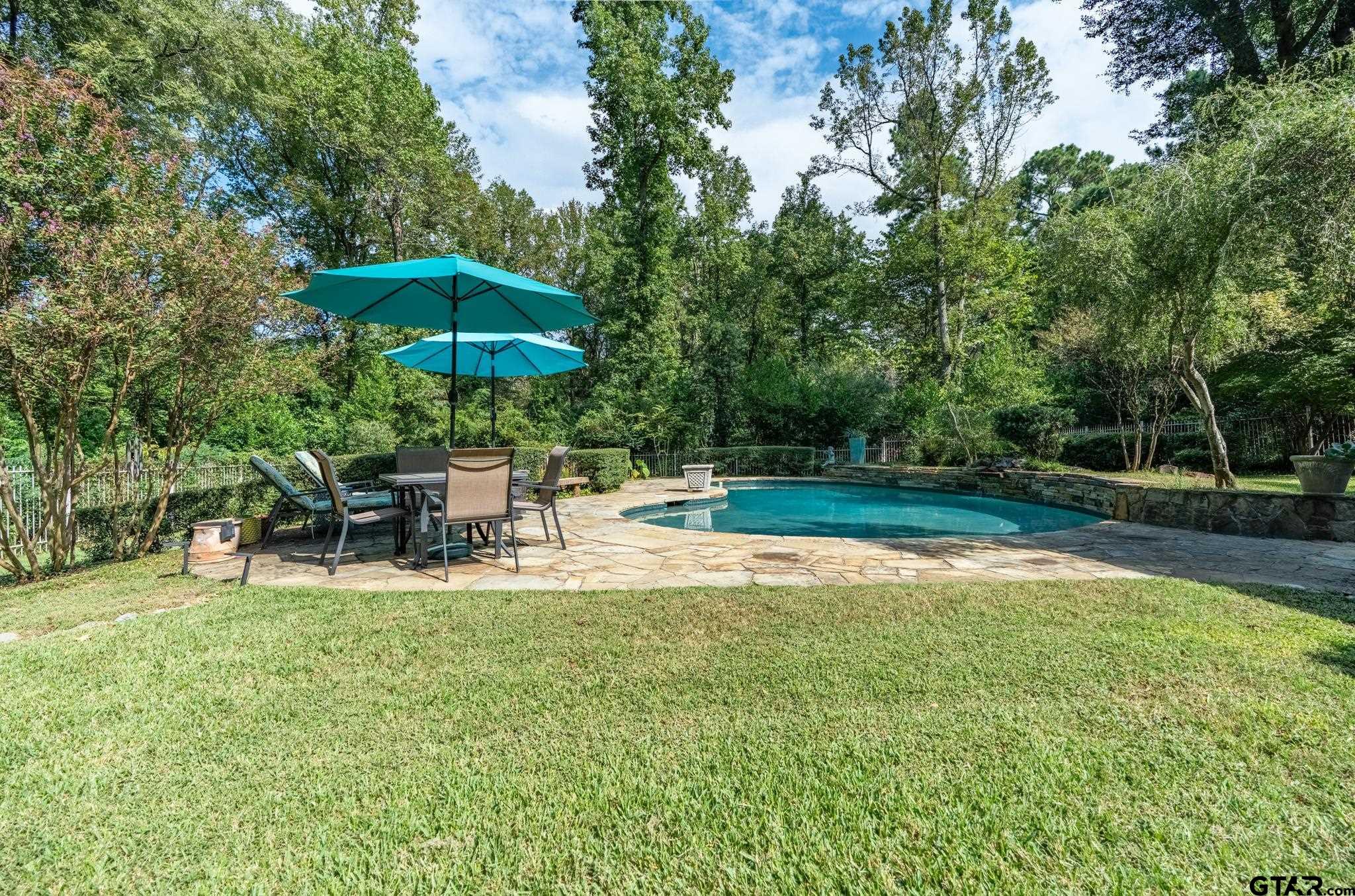 1520 Clubview Drive Tyler, TX 75701 - Photo 46 of 48 a view of a chair and table with umbrella in the garden