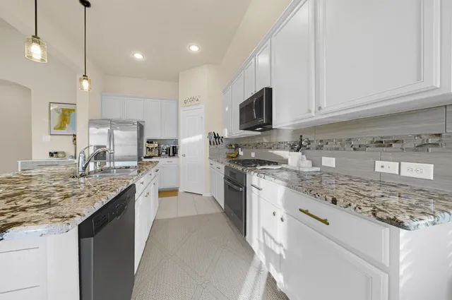 a kitchen with stainless steel appliances granite countertop a sink stove and cabinets