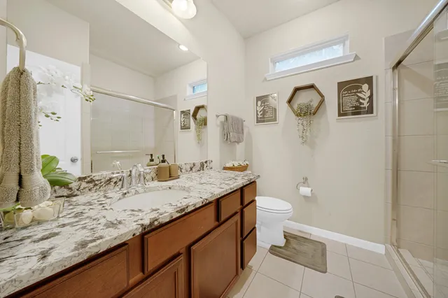 a bathroom with a granite countertop sink toilet and shower
