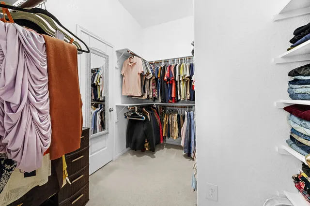a view of walk in closet with clothes and shoes