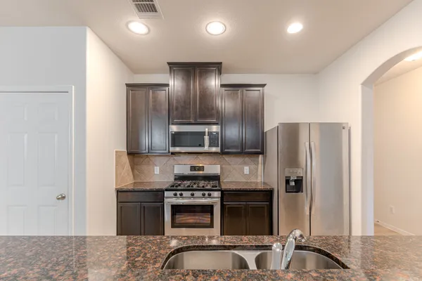 a kitchen with stainless steel appliances a refrigerator and a stove top oven