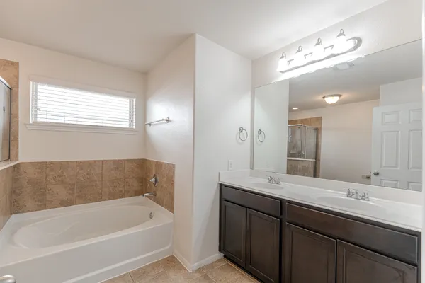 a bathroom with a tub a sink and mirror