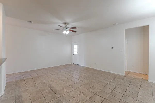 an empty room with white walls and fan
