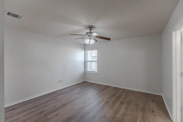 wooden floor in an empty room with a window