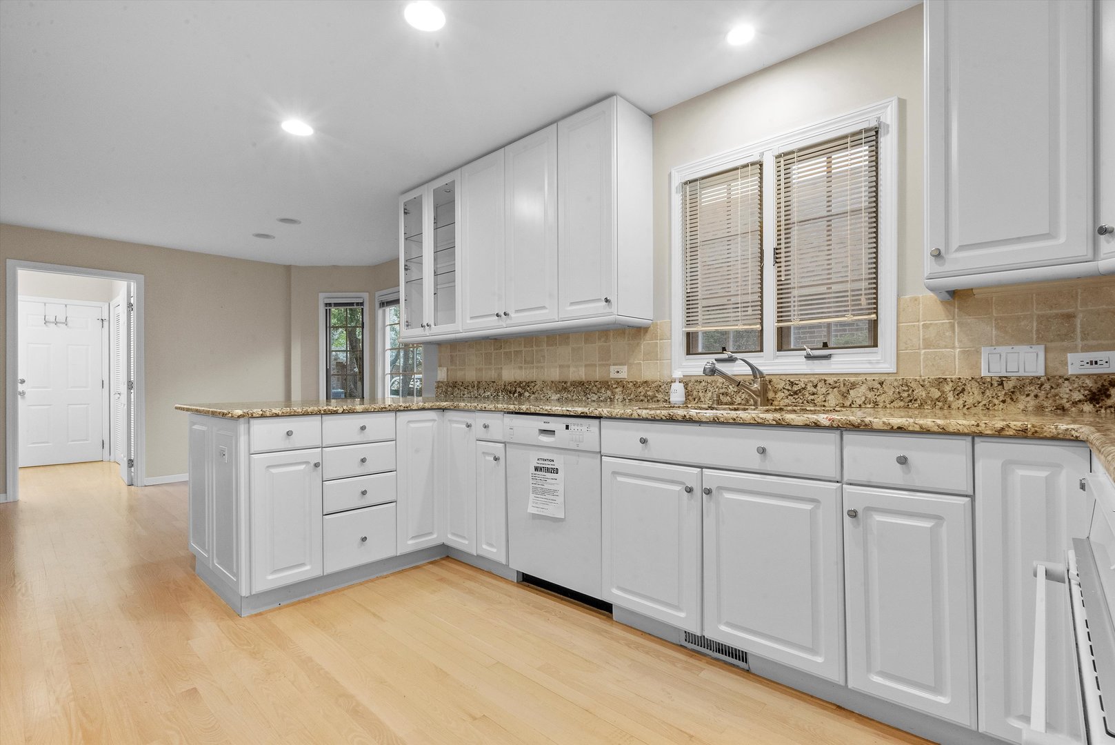 341 Rivershire Court Lincolnshire, IL 60069 - Photo 16 of 32 a kitchen with granite countertop white cabinets and white stainless steel appliances