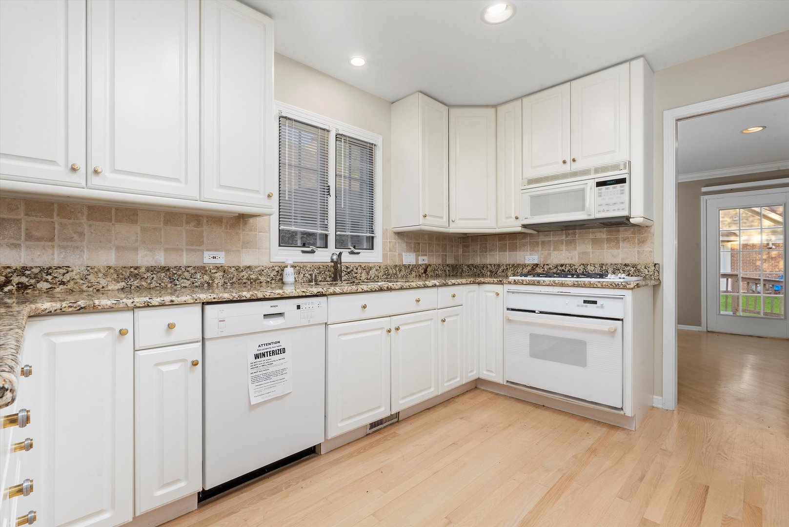 341 Rivershire Court Lincolnshire, IL 60069 - Photo 17 of 32 a kitchen with granite countertop white cabinets and white appliances