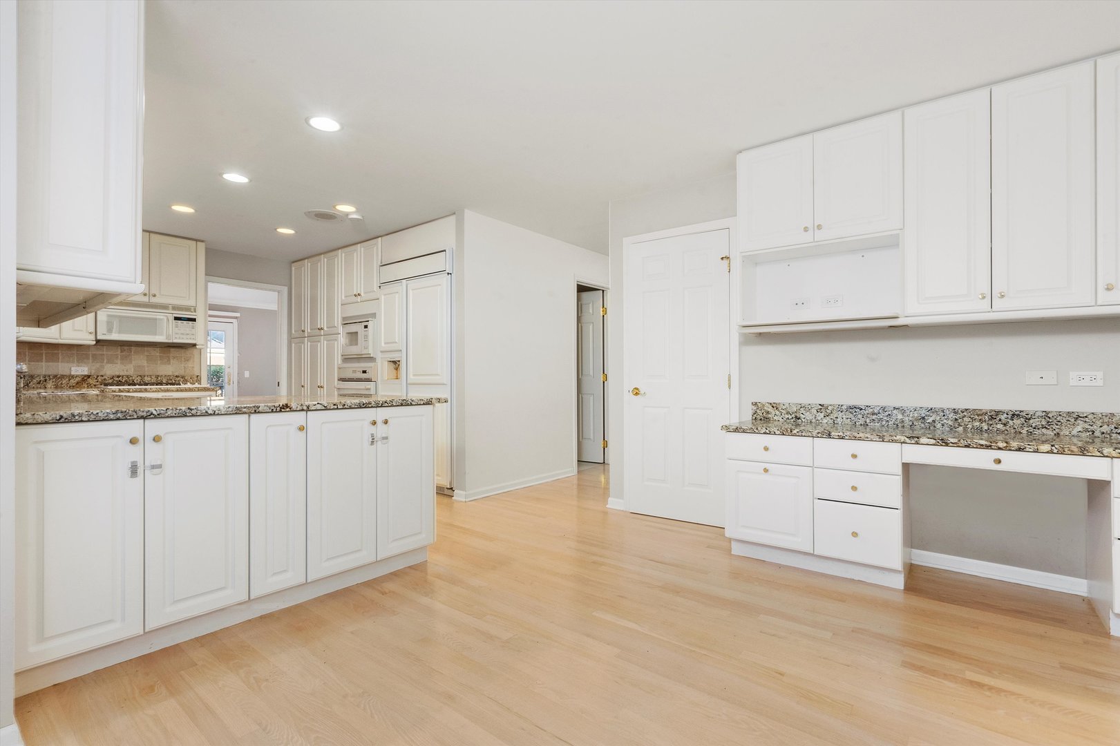 341 Rivershire Court Lincolnshire, IL 60069 - Photo 18 of 32 a kitchen with granite countertop white cabinets and white appliances