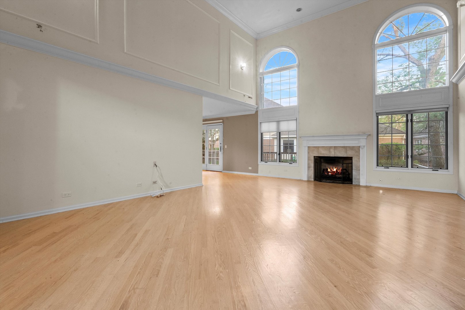 341 Rivershire Court Lincolnshire, IL 60069 - Photo 6 of 32 an empty room with windows fireplace and a wooden floor