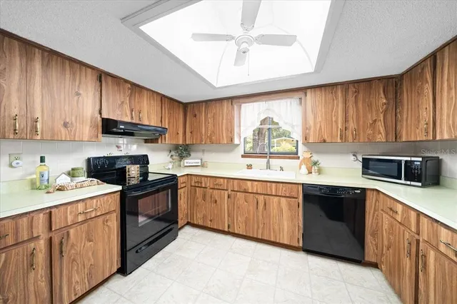 a kitchen with stainless steel appliances granite countertop a stove sink microwave and cabinets