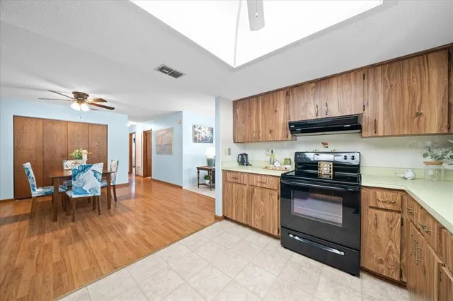 a kitchen with stainless steel appliances granite countertop a stove top oven a sink dishwasher and cabinets with wooden floor