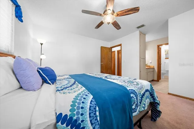 a bedroom with a large bed and a chandelier