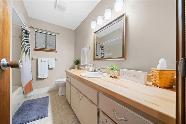 a bathroom with a granite countertop sink mirror vanity and toilet