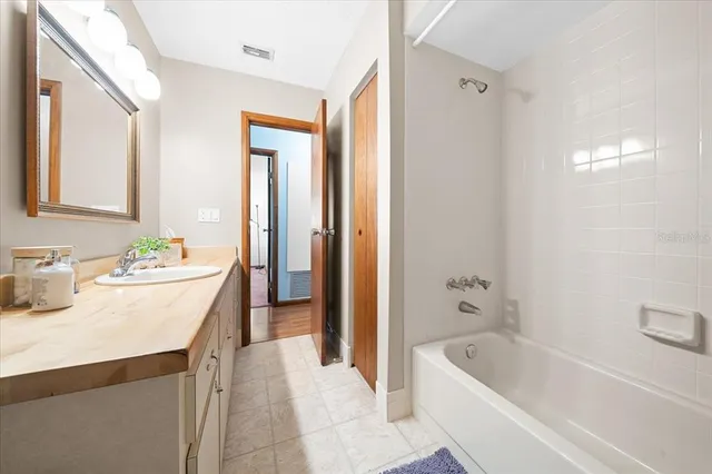a bathroom with a tub a sink and a large mirror