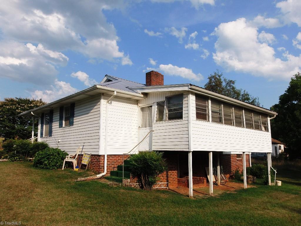 Back of home showing sunroom and basement outside entrance.
