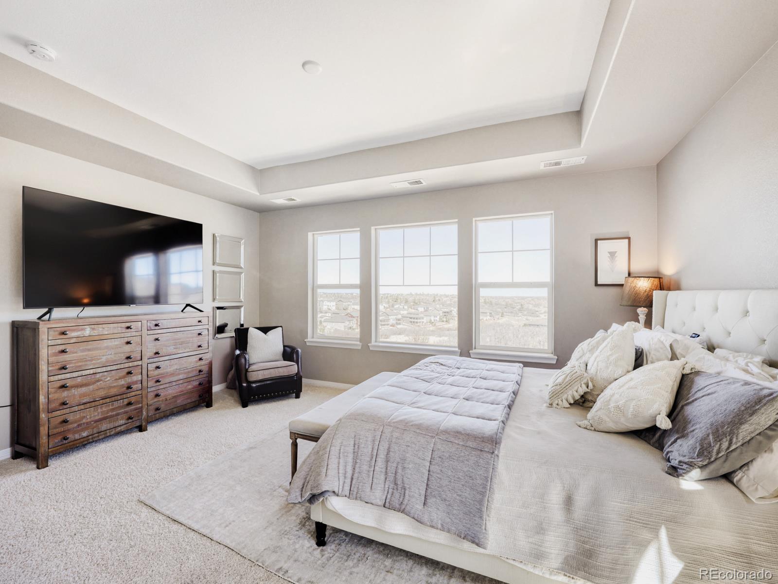 2964 Whitewing Way Castle Rock, CO 80108 - Photo 15 of 31 a bedroom with a large bed and a flat screen tv