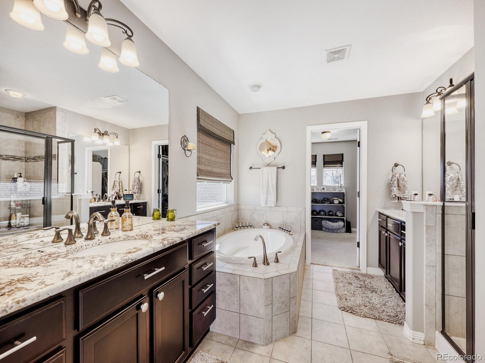 2964 Whitewing Way Castle Rock, CO 80108 - Photo 17 of 31 a spacious bathroom with a granite countertop sink mirror and shower