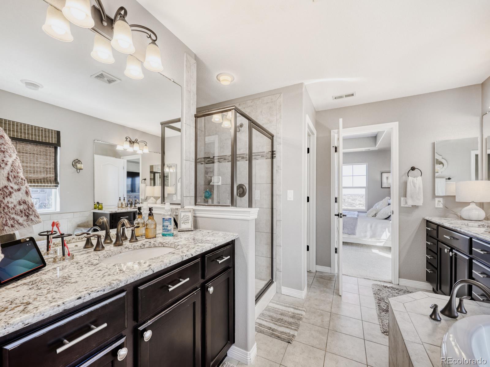 2964 Whitewing Way Castle Rock, CO 80108 - Photo 18 of 31 a spacious bathroom with a granite countertop sink mirror and bathtub