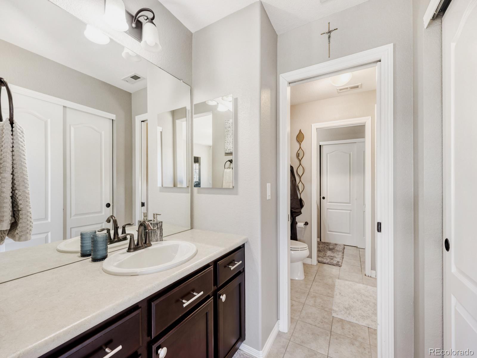 2964 Whitewing Way Castle Rock, CO 80108 - Photo 22 of 31 a en suite bathroom with a granite countertop sink and a mirror