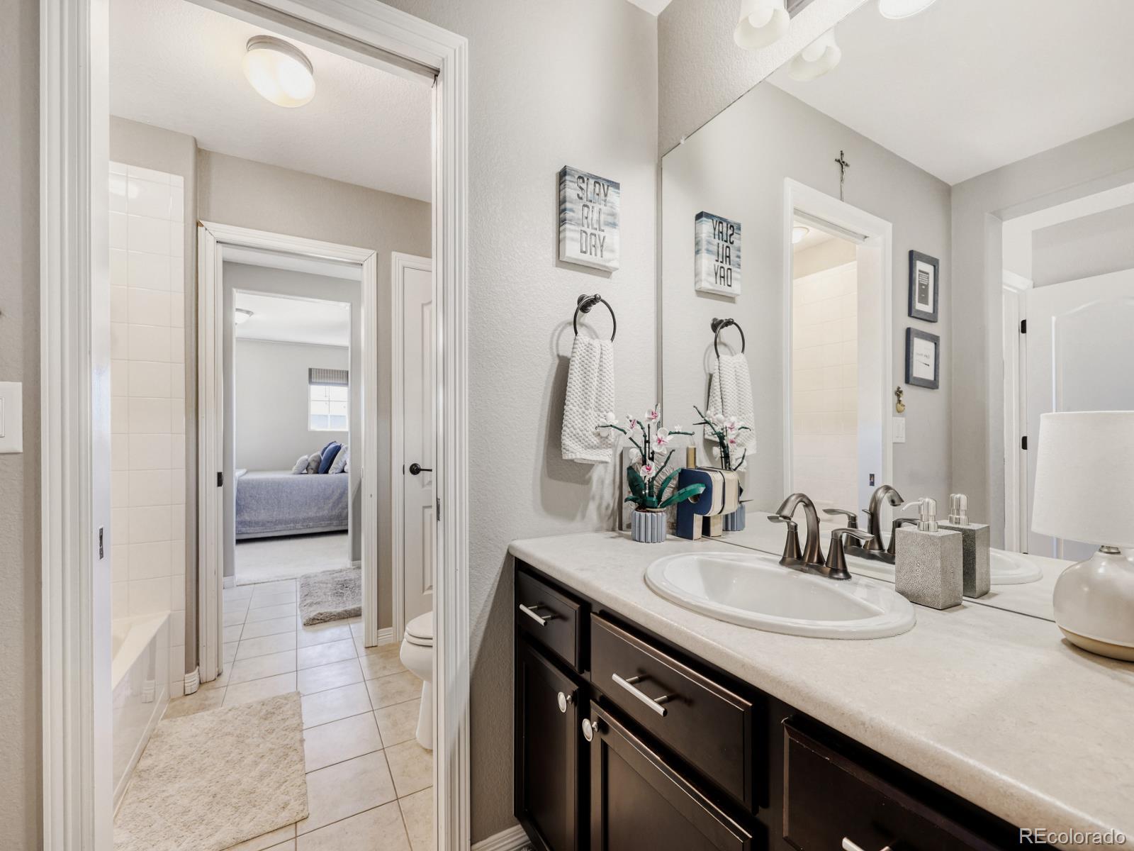 2964 Whitewing Way Castle Rock, CO 80108 - Photo 23 of 31 a en suite bathroom with a granite countertop sink and a mirror